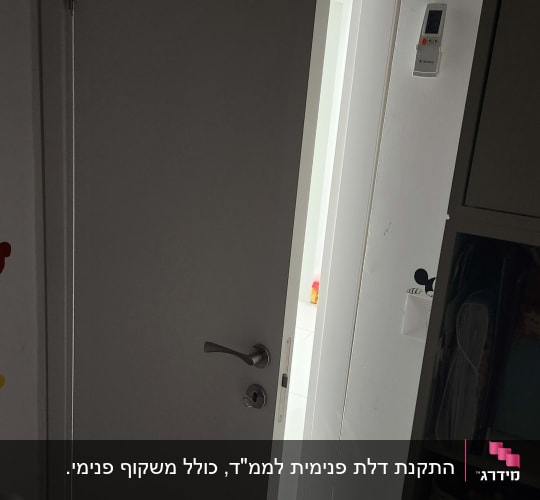 דלת לבנה פתוחה למחצה עם ידית מתכת